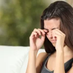 A woman rubbing her eyes