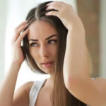 A woman scratching her head