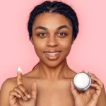 A woman holding up a skincare product