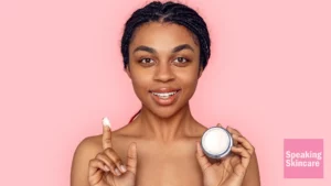 A woman holding up a skincare product