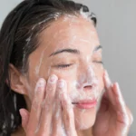 A woman using a face cleanser