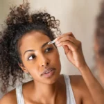 A woman applying eyebrow serum