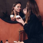 A woman applying moisturiser
