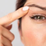 A woman pointing at her eyes