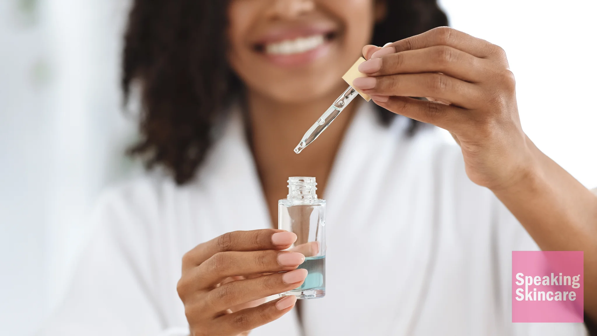 A woman holding a serum bottle