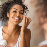 A woman applying face cream