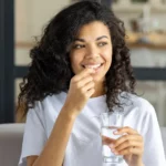 A woman taking a vitamin