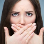 A woman covering her mouth.